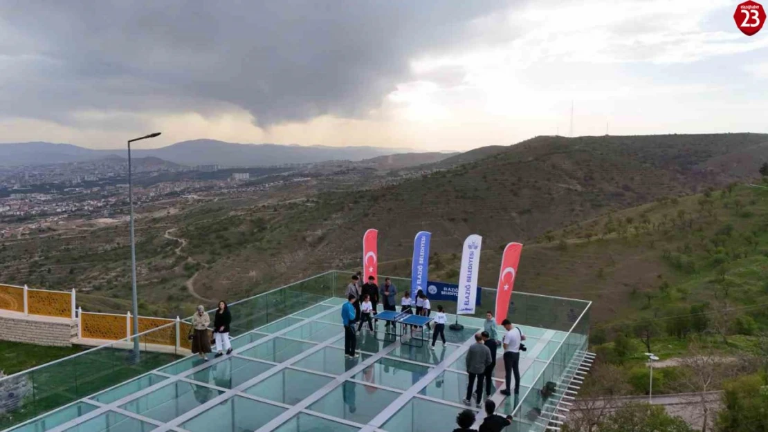 Cam teras üzerinde masa tenisi karşılaşması, renkli görüntüler oluşturdu
